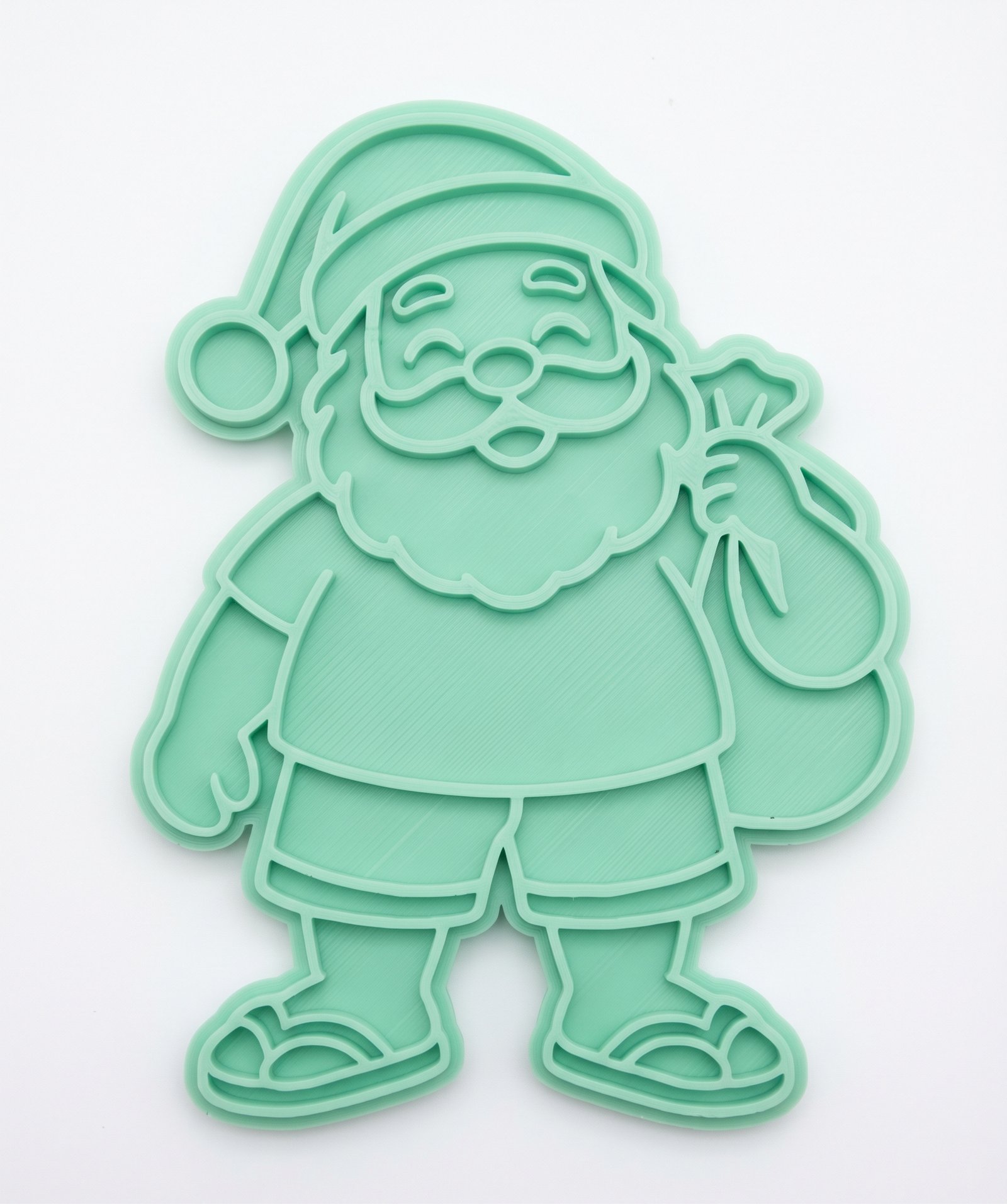 Cortador e marcador de biscoito em plástico verde claro no formato de Papai Noel tropical de bermuda e chinelo.