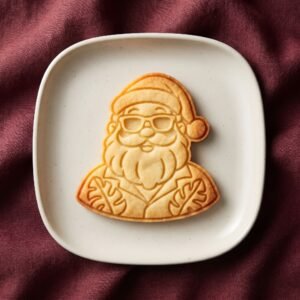 Biscoito assado decorado no formato de Papai Noel de férias usando óculos de sol e camisa florada